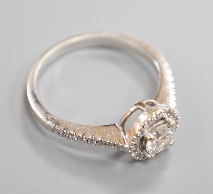 A modern 18ct white gold and single stone diamond ring with diamond chip circular setting and diamond chip set shoulders, from The Diamond Store, London